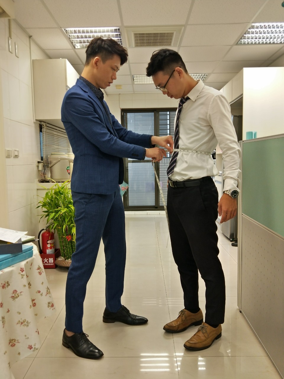 歐爵為顧客進行西服腰身量身